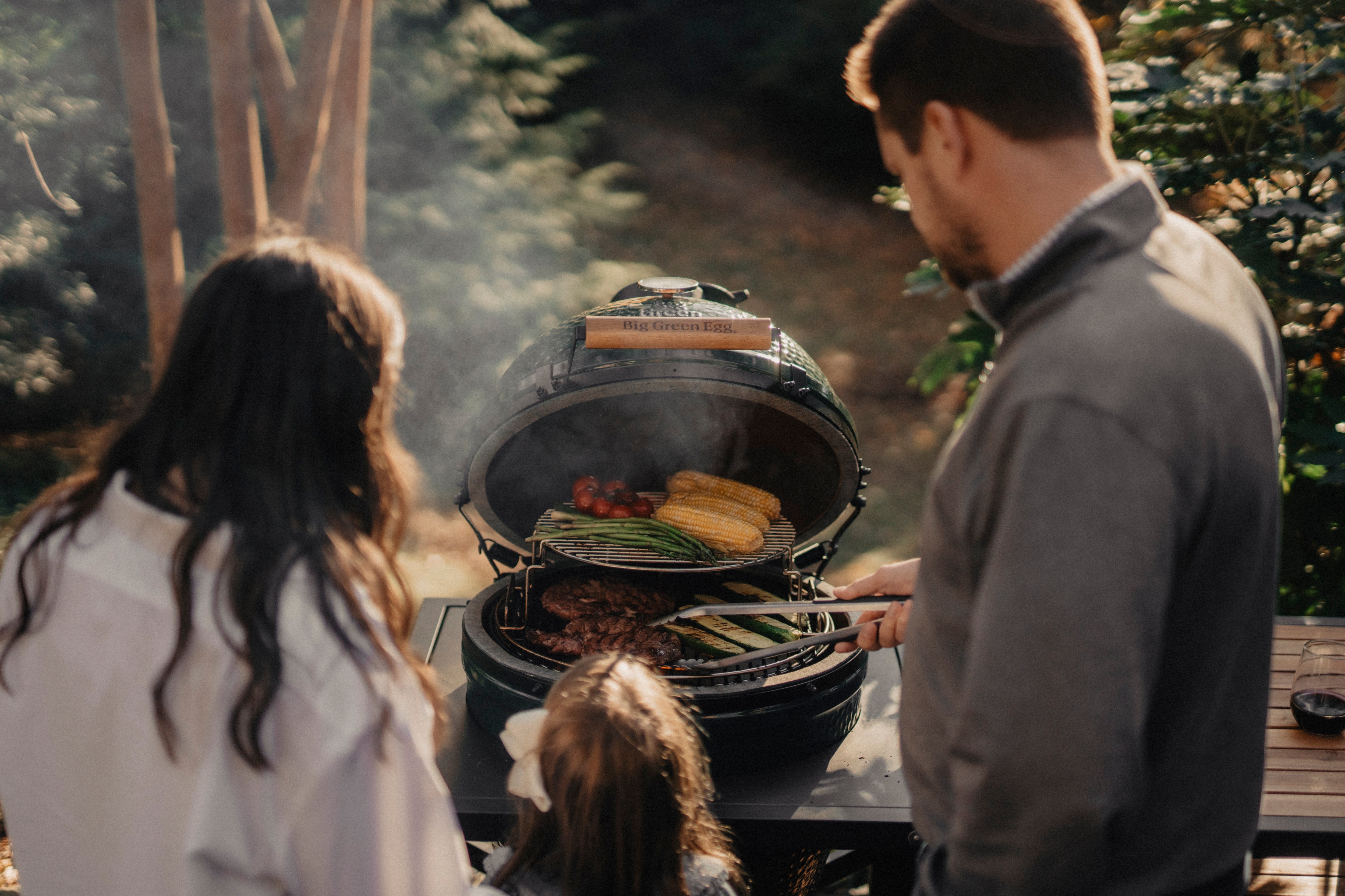 Family grilling on Big Green Egg