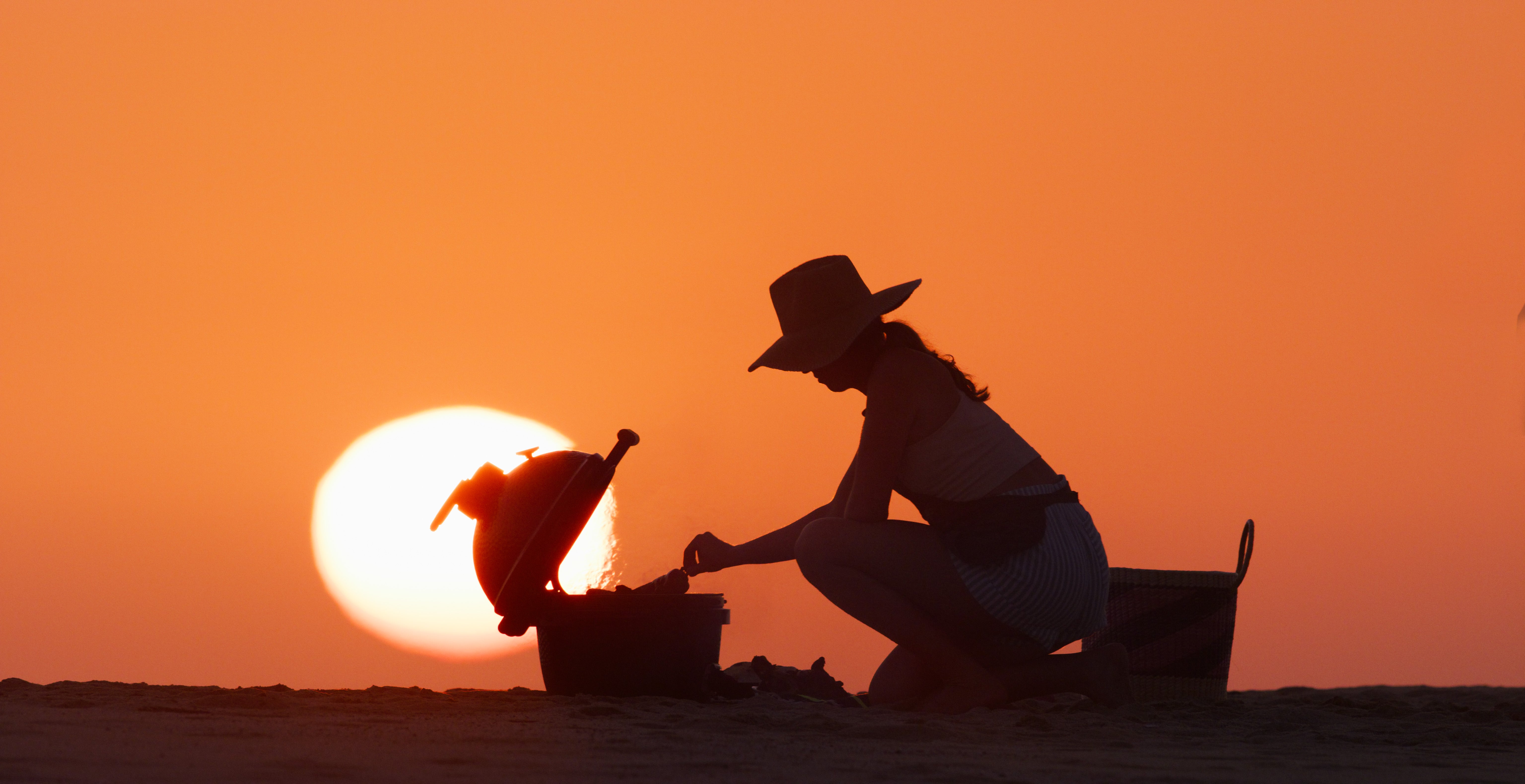 A woman outdoors cooking on a big green egg
