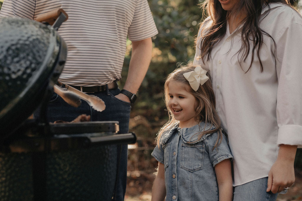 Girl watching her father cook on a Big Green Egg