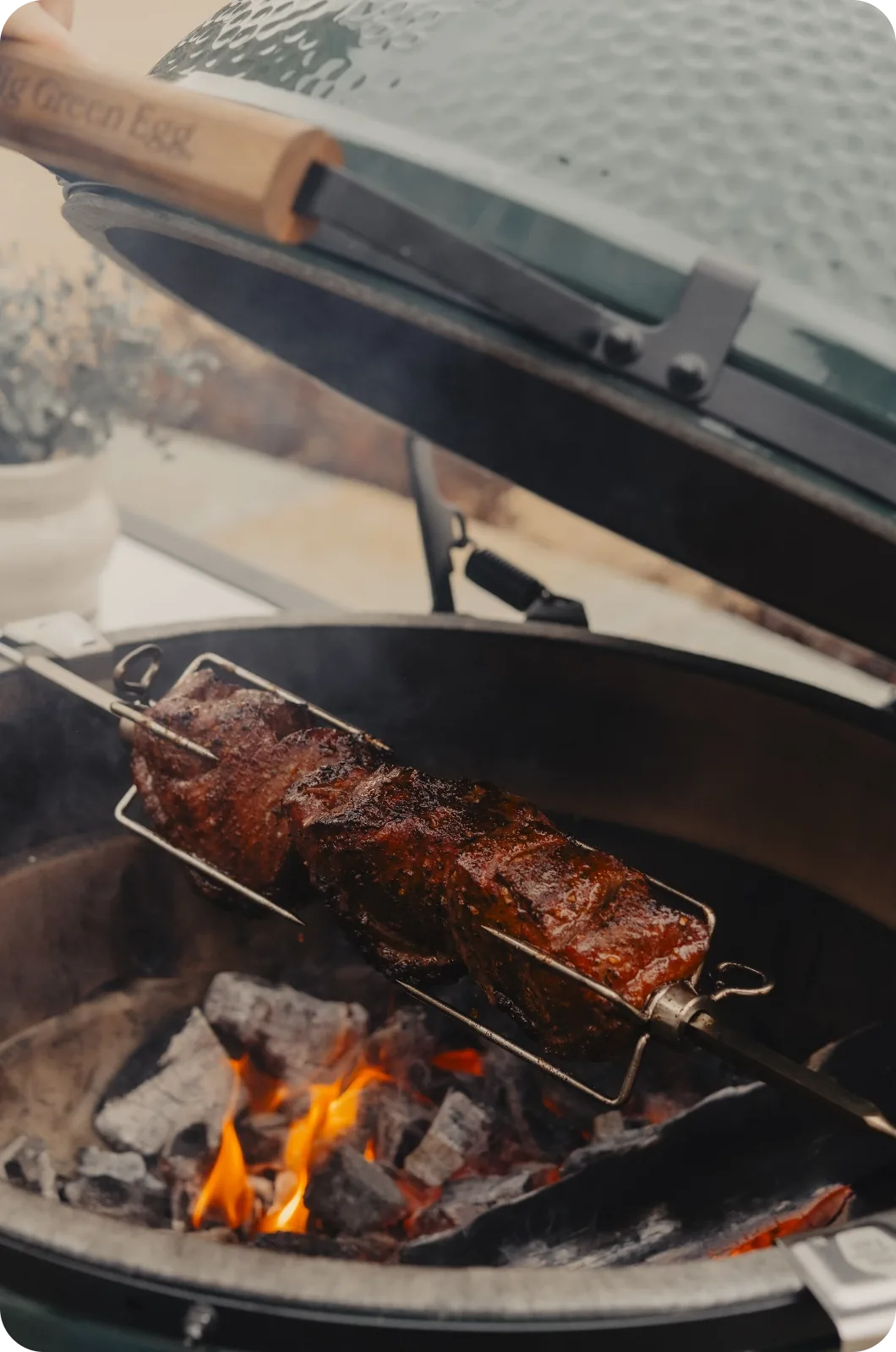 Grilled meat on a skewer over an open grill with visible flames