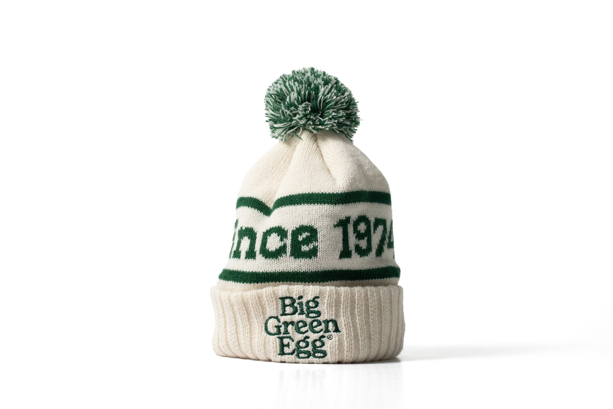 White knit beanie with green text and pom-pom on a white background