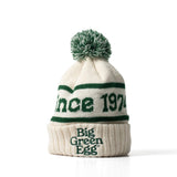 White knit beanie with green text and pom-pom on a white background