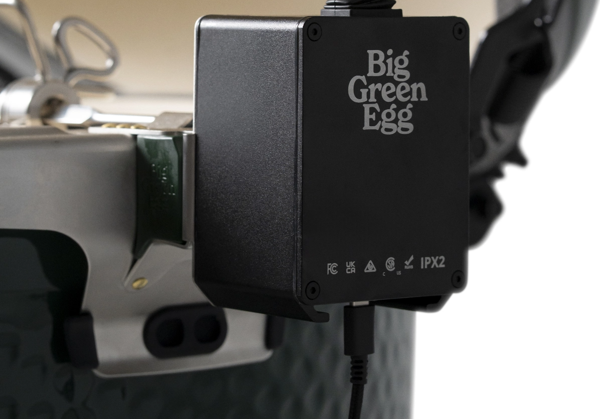 Black electronic motor with 'Big Green Egg' branding attached to a grill.