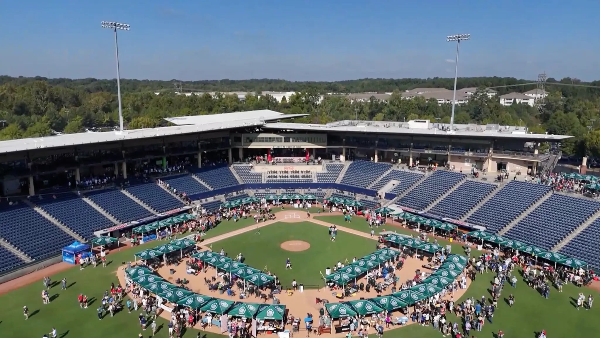 Outdoor sports facility with blue seats and green grass hosting Eggtoberfest.